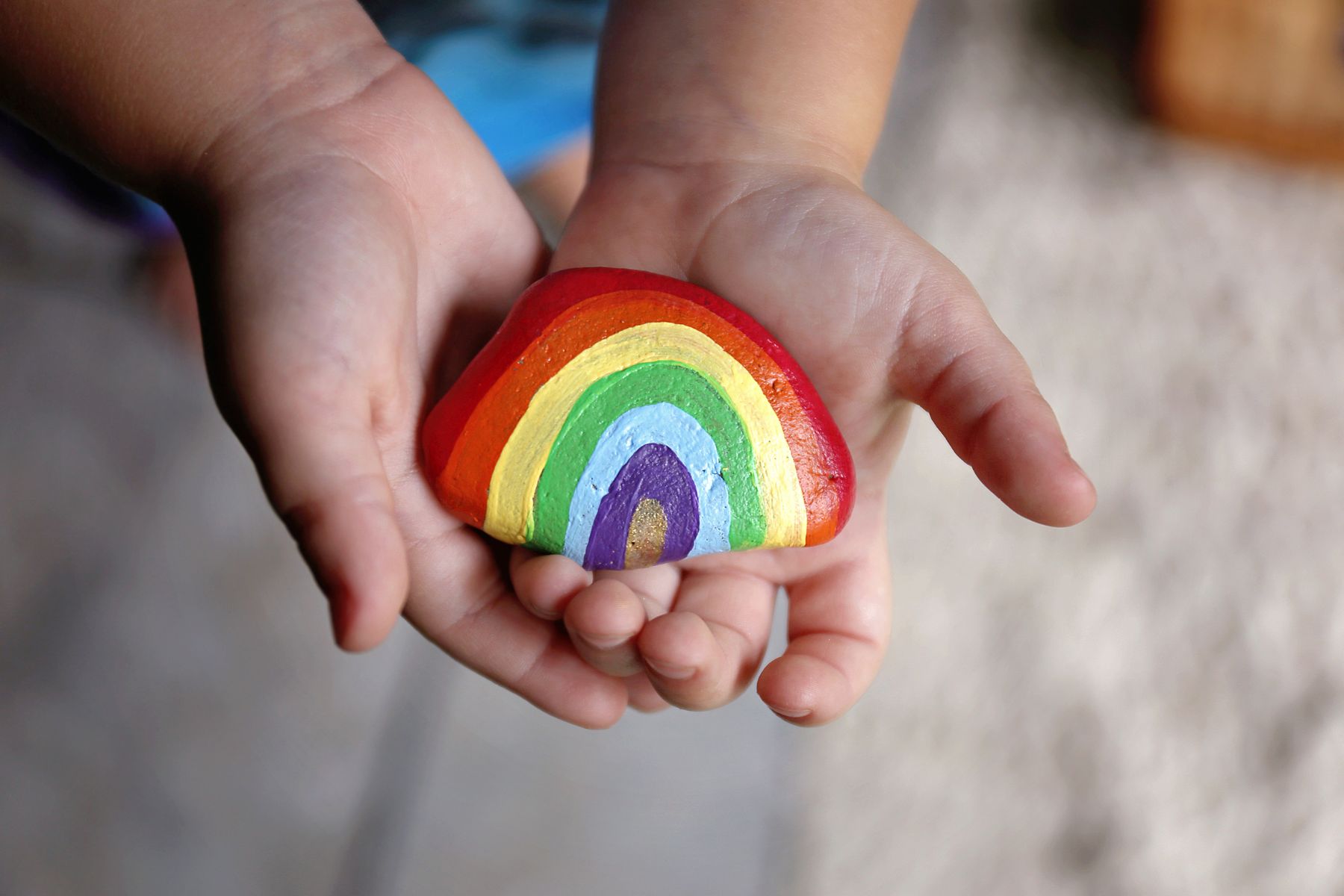 child hands holding rainbow